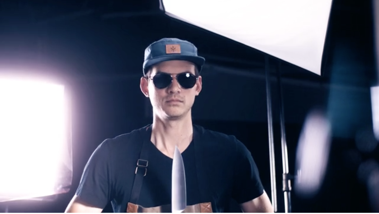 Man holding knife and wearing a chef's apron on the set of a Sharkninja video shoot